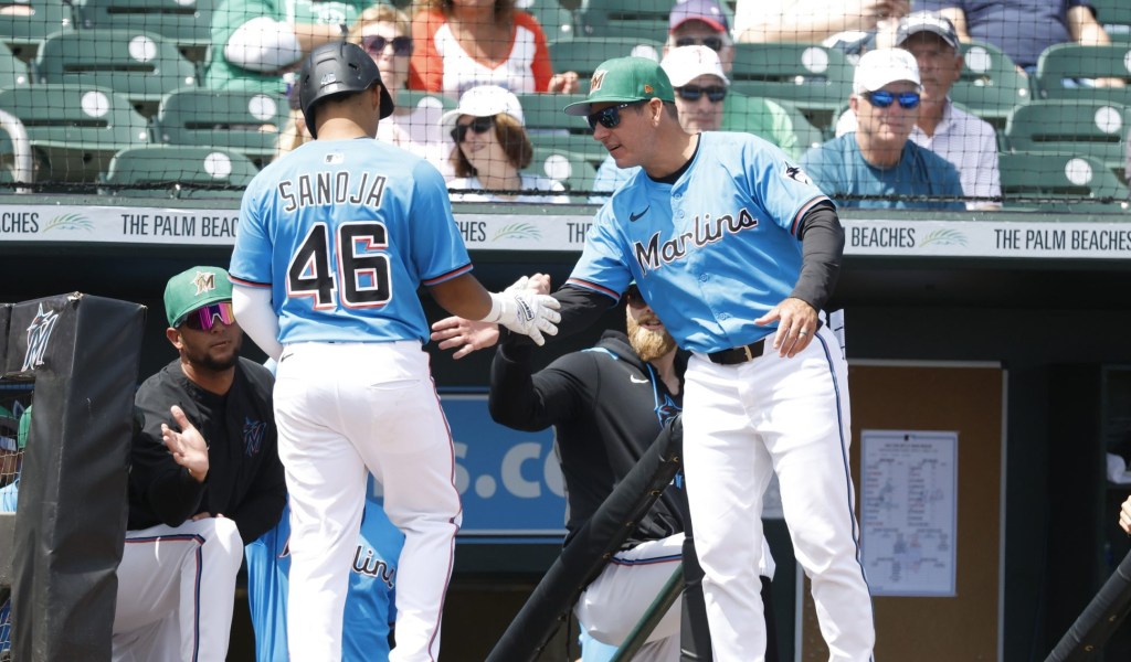 Mar 17, 2025; Jupiter, Florida, USA; Miami Marlins second baseman Javier Sanoja (46) is congratulated by Miami Marlins manager Clayton McCullough (86) after scoring against the New York Mets during the third inning at Roger Dean Chevrolet Stadium.