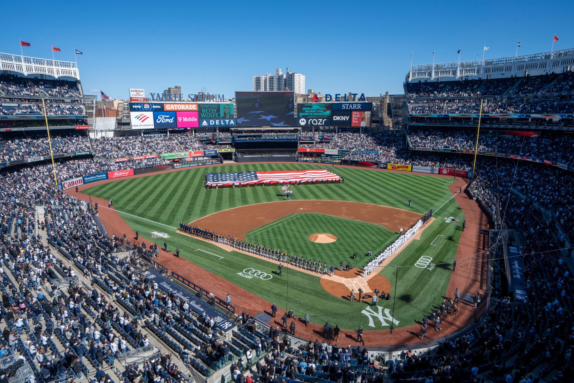 Both teams line the field during the singing of the national anthem prior to the start of the opening day game between the NY Yankees and Milwaukee Brewers at Yankee Stadium on Thursday, March 27, 2025.