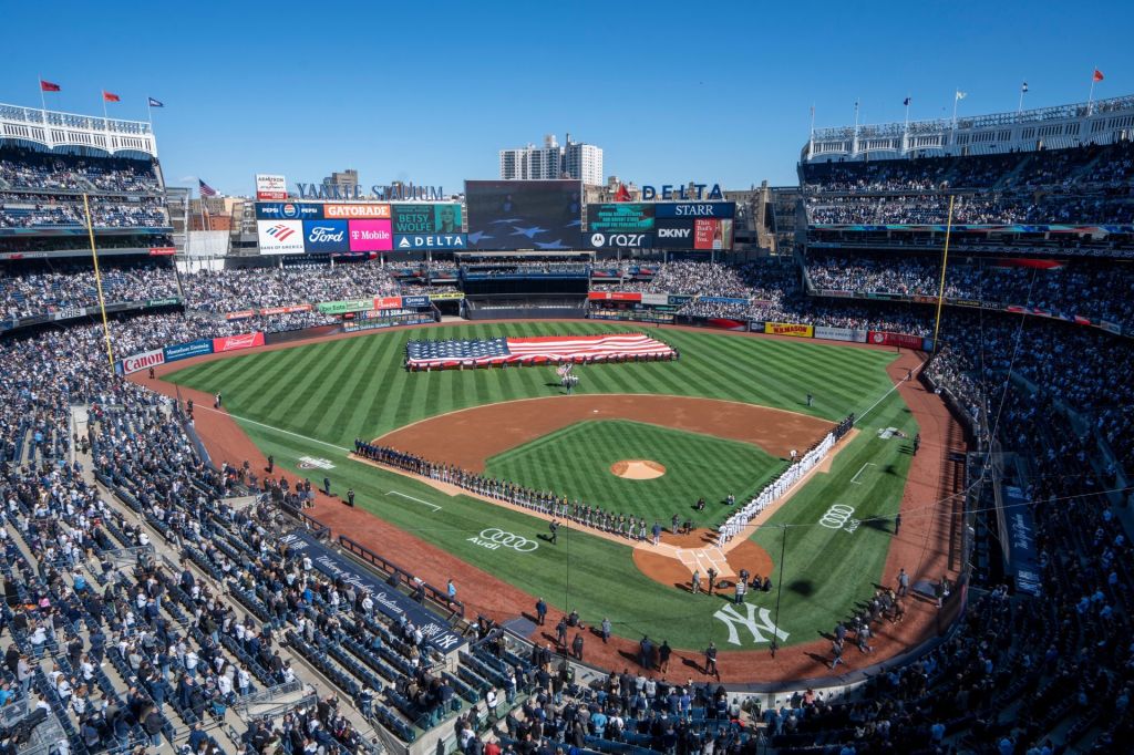 Both teams line the field during the singing of the national anthem prior to the start of the opening day game between the NY Yankees and Milwaukee Brewers at Yankee Stadium on Thursday, March 27, 2025.
