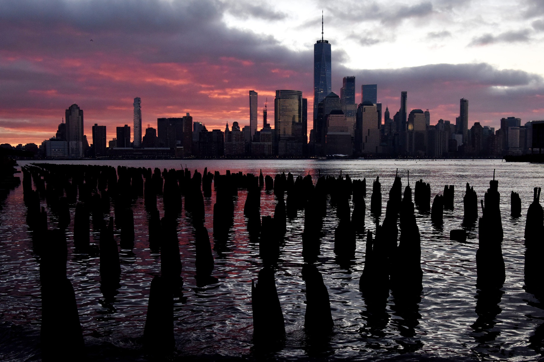 The sun rises behind the New York skyline seen from the Jersey City waterfront on Thursday morning Dec. 10, 2020.