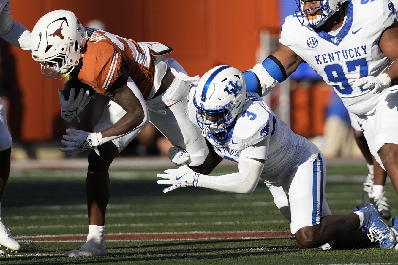 Nov 23, 2024; Austin, Texas, USA; Texas Longhorns running back Quintrevion Wisner (26) is tackled by Kentucky Wildcats defensive back Alex Afari Jr.(3) during the first half at Darrell K Royal-Texas Memorial Stadium.