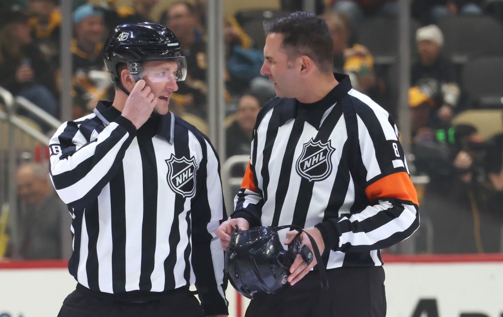 Apr 8, 2025; Pittsburgh, Pennsylvania, USA; NHL linesman Tyson Baker (88) and referee Francois St. Laurent (8) talk before the game between the Chicago Blackhawks and the Pittsburgh Penguins at PPG Paints Arena