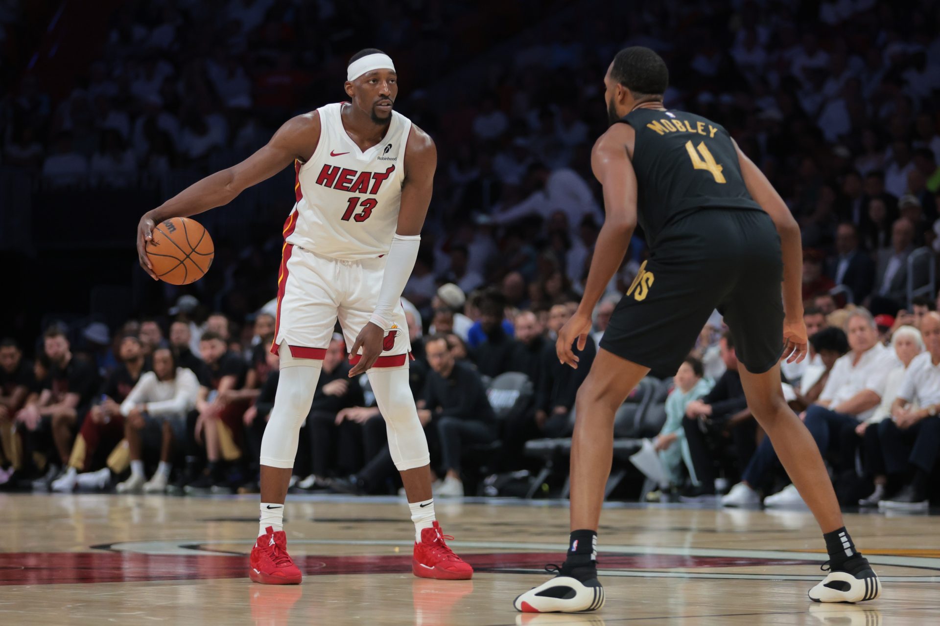 Apr 26, 2025; Miami, Florida, USA; Miami Heat center Bam Adebayo (13) dribbles the basketball as Cleveland Cavaliers forward Evan Mobley (4) defends in the third quarter during game three for the first round of the 2025 NBA Playoffs at Kaseya Center.