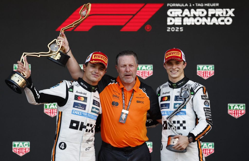 May 25, 2025; MONACO; McLaren's Lando Norris celebrates with a trophy on the podium after winning the Monaco Grand Prix alongside third placed McLaren's Oscar Piastri and McLaren chief executive Zak Brown at Circuit de Monaco.