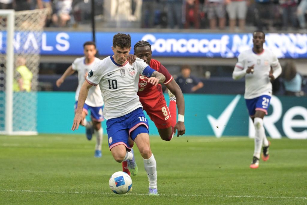 Mar 23, 2025; Inglewood, California, USA; United States of America forward Christian Pulisic (10) kicks th eblal past Canada midfielder Ismael Kone (8) in the first half during the Concacaf Nations League third place match at SoFi Stadium.