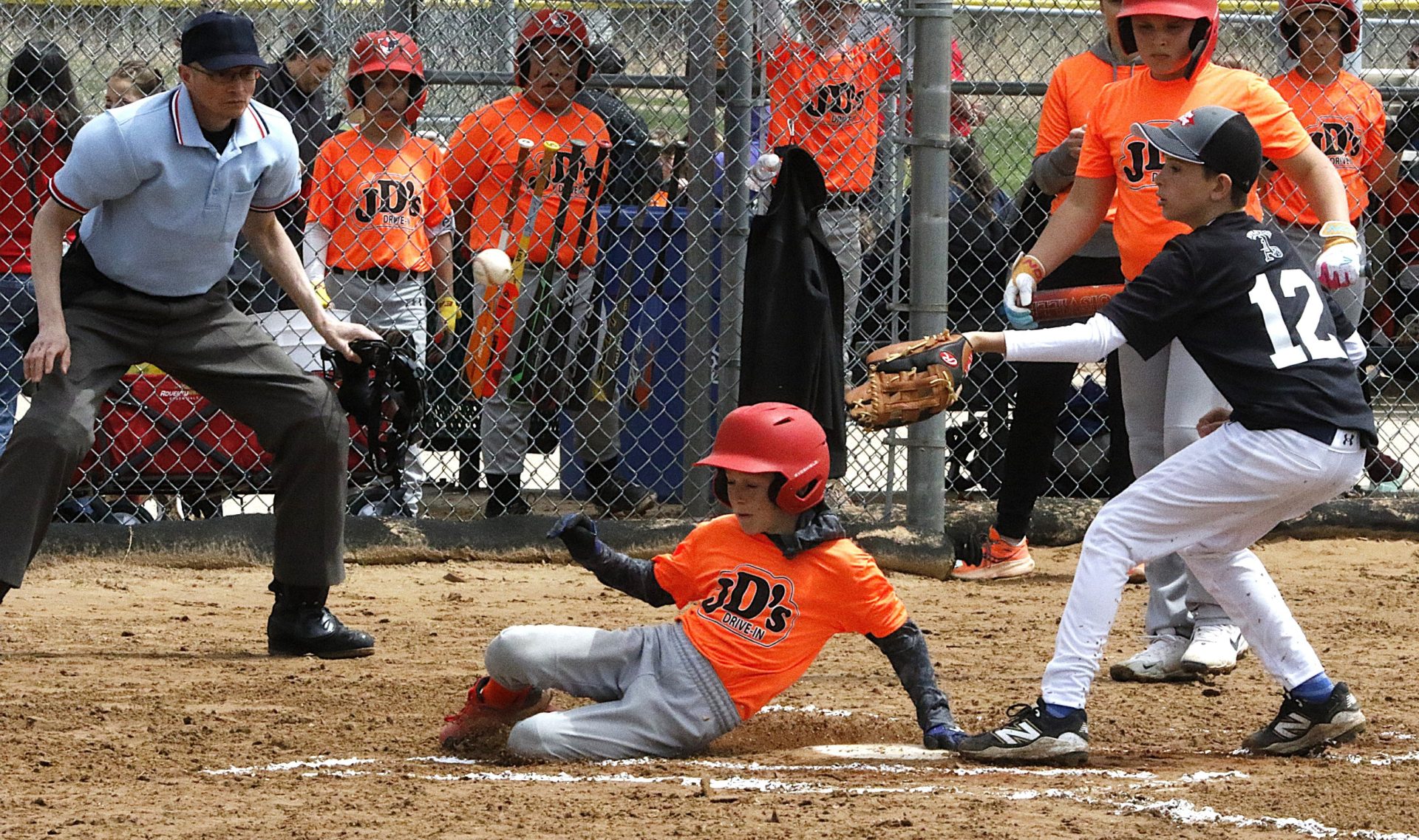 JD's Drive In's Bennett Swanson slides into home plate ahead of a throw during Appleton Little League Opening Day on Saturday, May 3, 2025 at Memorial Park in Appleton, Wisconsin.
