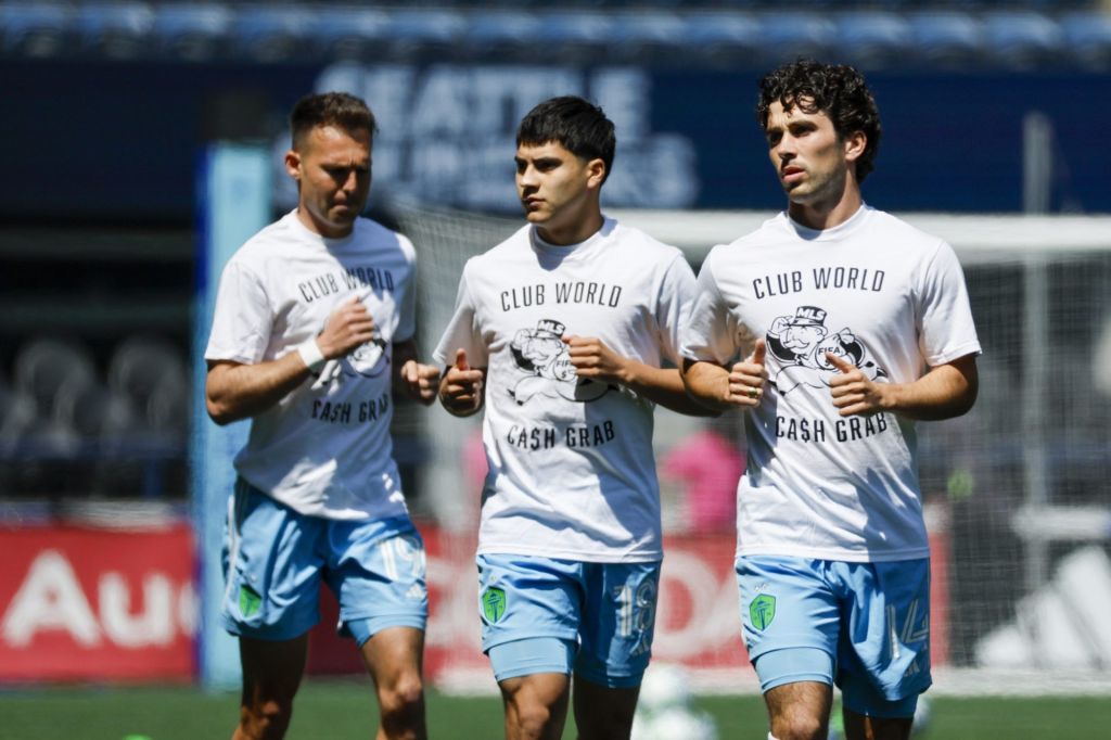 Jun 1, 2025; Seattle, Washington, USA; Seattle Sounders FC forward Danny Musovski (19), midfielder Obed Vargas (18) and midfielder Paul Rothrock (14) wear t-shirts to protest FIFA Club World Cup bonus sharing from MLS while participating in pregame warmups against the Minnesota United at Lumen Field.