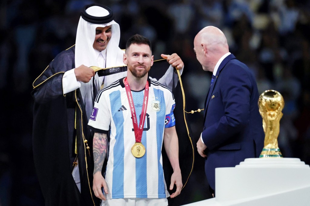 Dec 18, 2022; Lusail, Qatar; Qatar Emir Sheikh Tamim bin Hamad al Thani presents Argentina forward Lionel Messi (10) with a traditional robe after he won the 2022 World Cup final against France at Lusail Stadium.