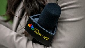 A Peacock sideline reporter holds a microphone with the NBC Peacock logo during Michigan State's football game against Washington on Saturday, Sept. 16, 2023, at Spartan Stadium in East Lansing.