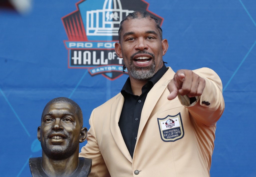 Aug 3, 2024; Canton, OH, USA; Class of 2024 member Julius Peppers poses with his bust at the enshrinement ceremony at Tom Benson Hall of Fame Stadium.