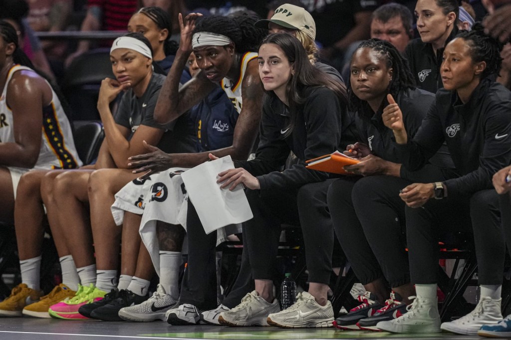 Jun 10, 2025; College Park, Georgia, USA; Indiana Fever injured guard Caitlin Clark (22) follows the action from the bench against the Atlanta Dream during the second half at Gateway Center Arena at College Park.
