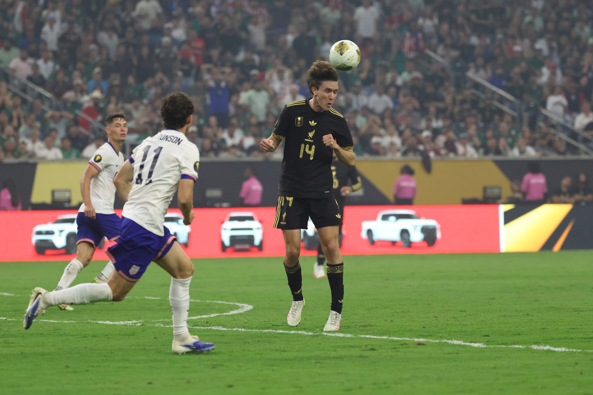 Jul 6, 2025; Houston, Texas, USA; Mexico forward Marcel Ruiz (14) heads the ball in front of United States midfielder Brenden Aaronson (11) in the second half during the 2025 Gold Cup Final at NRG Stadium.