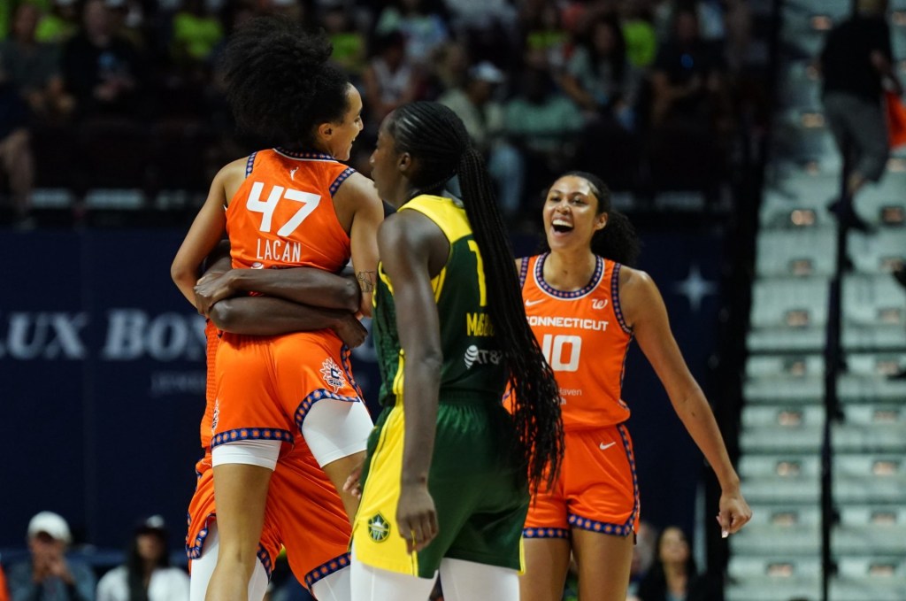 Jul 9, 2025; Uncasville, Connecticut, USA; Connecticut Sun center Tina Charles (31) hugs guard Leila Lacan (47) after a play against the Seattle Storm in the second half at Mohegan Sun Arena.
