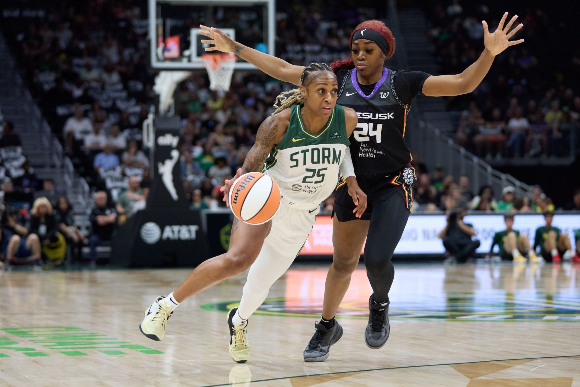 Jul 11, 2025; Seattle, Washington, USA; Seattle Storm guard Tiffany Mitchell (25) drives around Connecticut Sun forward Aneesah Morrow (24) during the first half at Climate Pledge Arena.