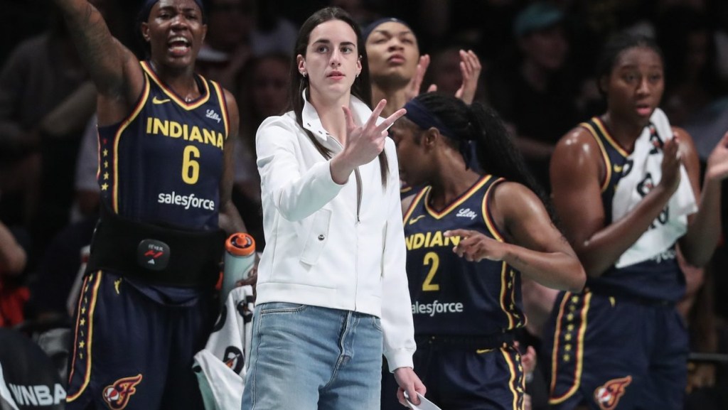 Jul 22, 2025; Brooklyn, New York, USA; Indiana Fever guard Caitlin Clark (not in uniform) celebrates from the bench in the first quarter against the New York Liberty at Barclays Center.
