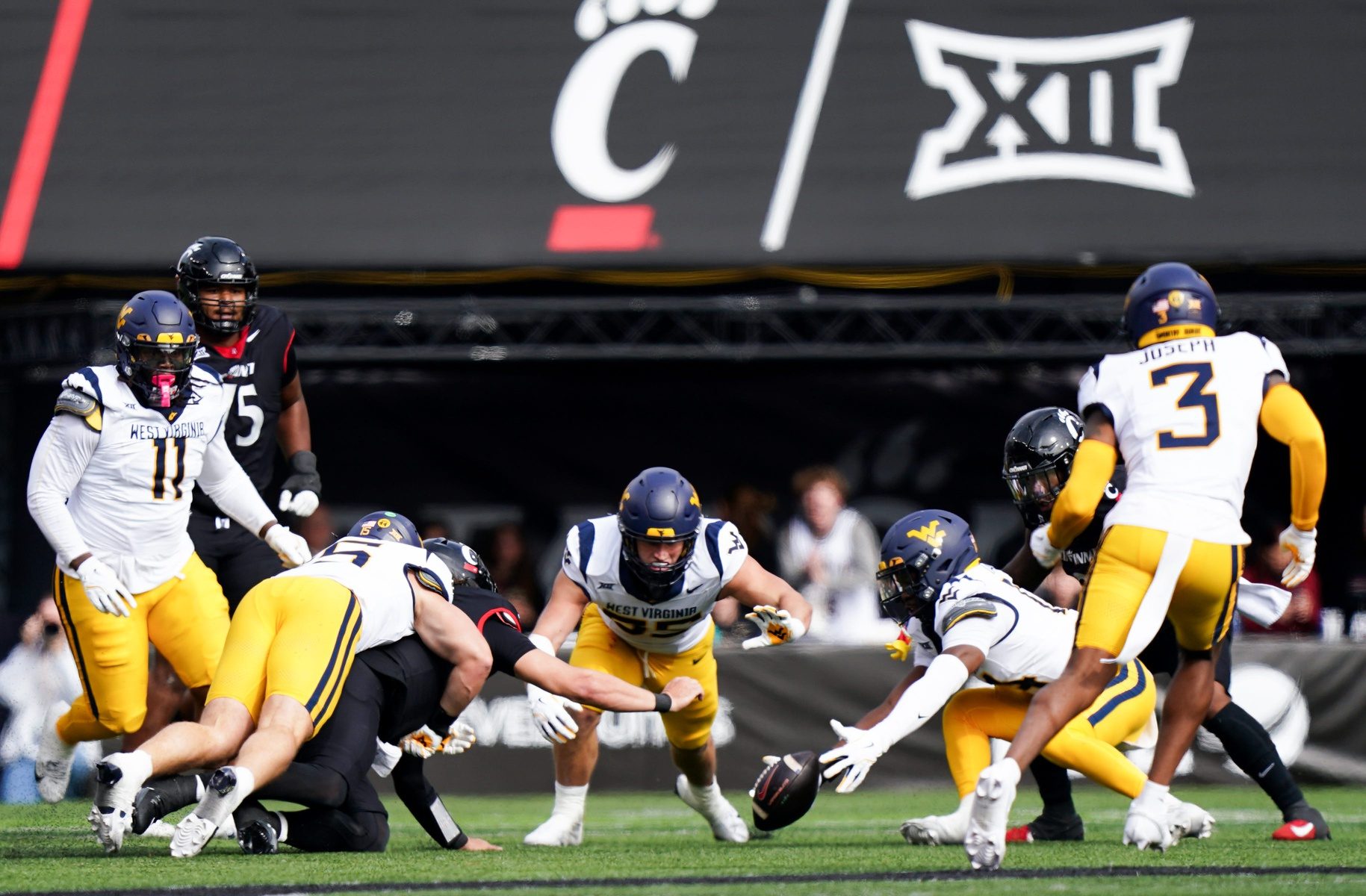 Cincinnati Bearcats quarterback Brendan Sorsby (2) attempts to gain possession of the ball against West Virginia Mountaineers players in the second quarter of a college football game between the Cincinnati Bearcats and West Virginia Mountaineers, Saturday, Nov. 9, 2024, at Nippert Stadium in Cincinnati.