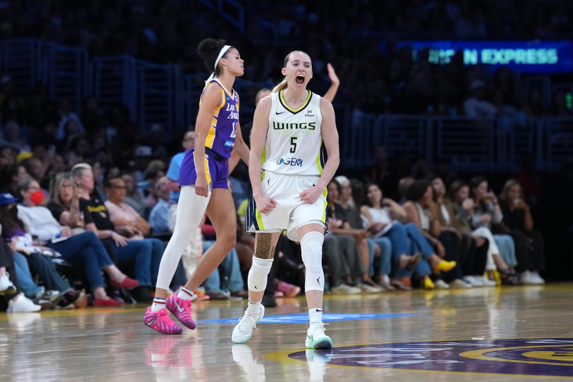 Aug 20, 2025; Los Angeles, California, USA; Dallas Wings guard Paige Bueckers (5) celebrates in the second half as LA Sparks guard Rae Burrell (12) watches at Crypto.com Arena.