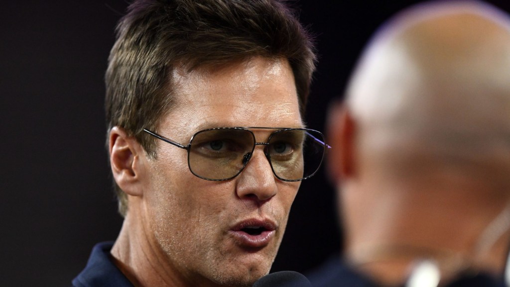 Aug 8, 2025; Foxborough, Massachusetts, USA; Retired Hall of Fame New England Patriot player Tom Brady talks with Brian Hoyer during the first half of a game against the Washington Commanders at Gillette Stadium.