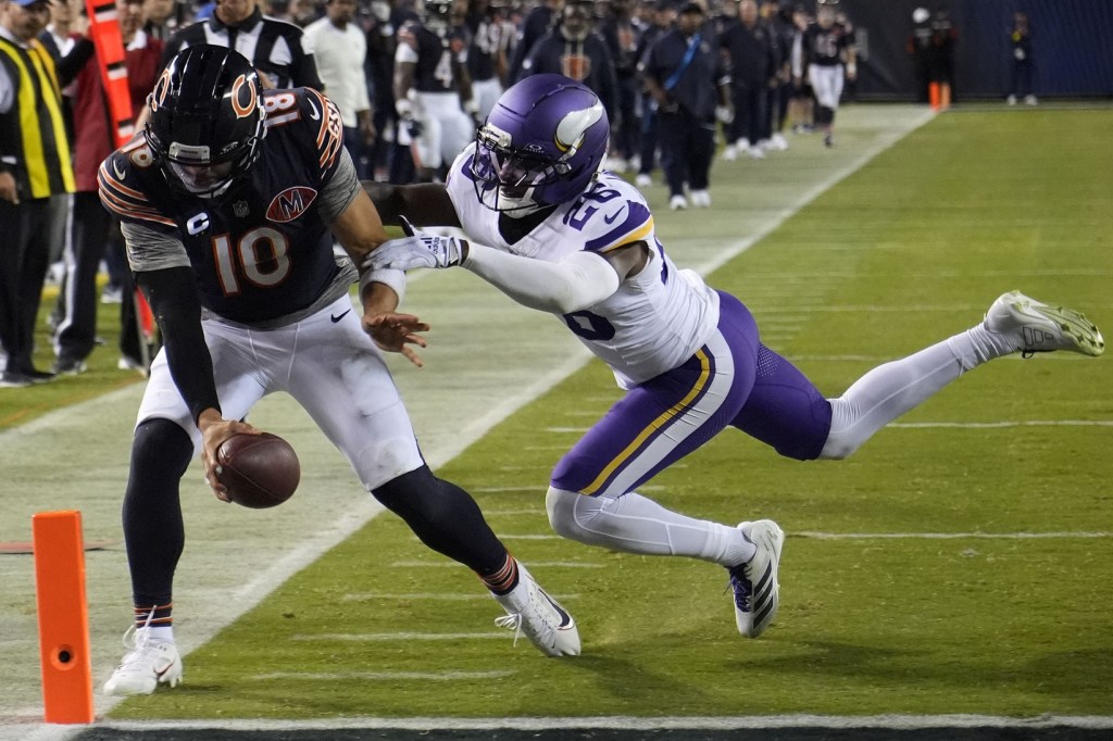 Sep 8, 2025; Chicago, Illinois, USA; Chicago Bears quarterback Caleb Williams (18) rushes the ball past Minnesota Vikings safety Theo Jackson (26) during the second half at Soldier Field.