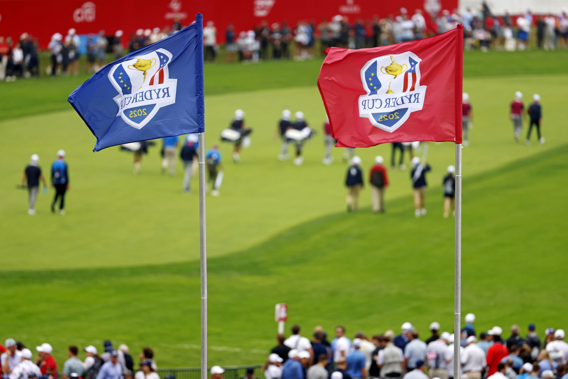 Sep 25, 2025; Bethpage, New York, USA; Ryder Cup flags fly over the first hole as Team Europe walks down the fairway during a practice round of the Ryder Cup golf tournament at Bethpage Black.