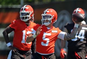 Cleveland Browns quarterback Dillon Gabriel (5) throws as quarterback Shedeur Sanders (12) looks on during rookie minicamp May 9, 2025, in Berea.