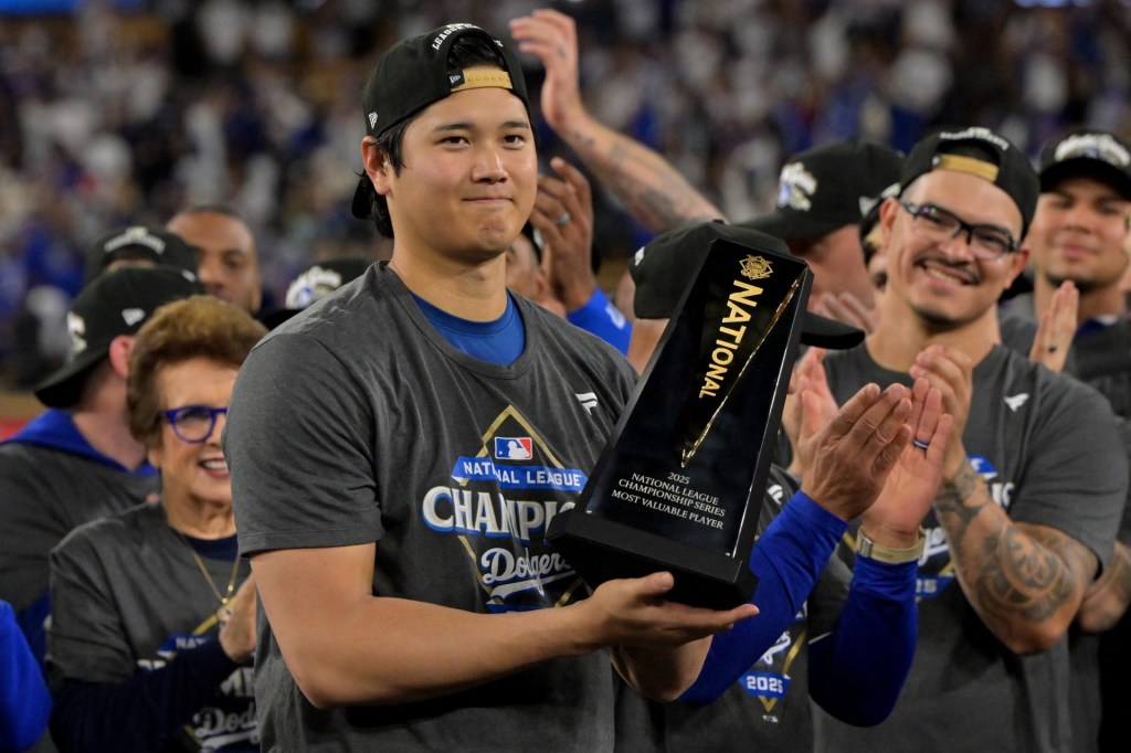 Oct 18, 2025; Los Angeles, California, USA; Los Angeles Dodgers two-way player Shohei Ohtani (17) holds the MVP trophy after defeating the Milwaukee Brewers in game five of the NLCS during the 2025 MLB playoffs at Dodger Stadium.