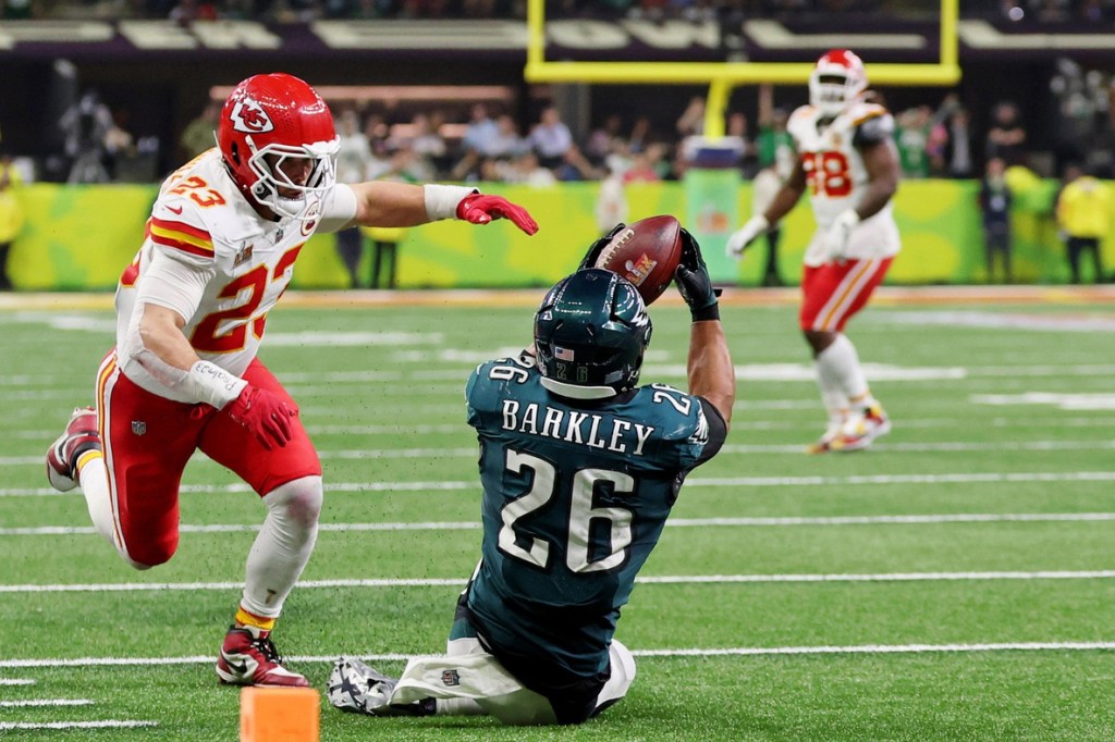 Feb 9, 2025; New Orleans, LA, USA; Philadelphia Eagles running back Saquon Barkley (26) makes a catch against Kansas City Chiefs linebacker Drue Tranquill (23) during the second half of Super Bowl LIX at Caesars Superdome.