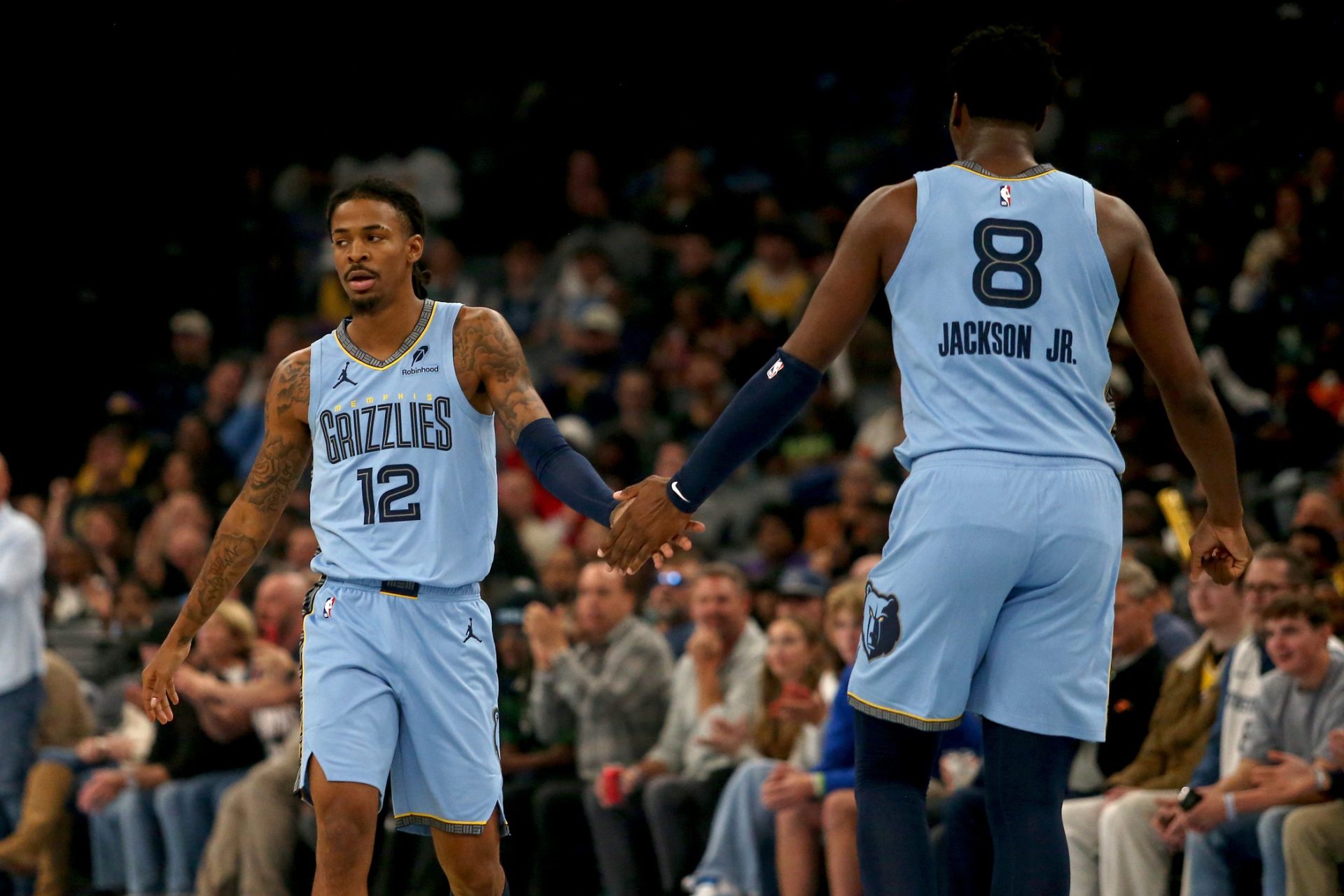 Oct 31, 2025; Memphis, Tennessee, USA; Memphis Grizzlies guard Ja Morant (12) reacts with forward/center Jaren Jackson Jr. (8) during the first quarter against the Los Angeles Lakers at FedExForum.