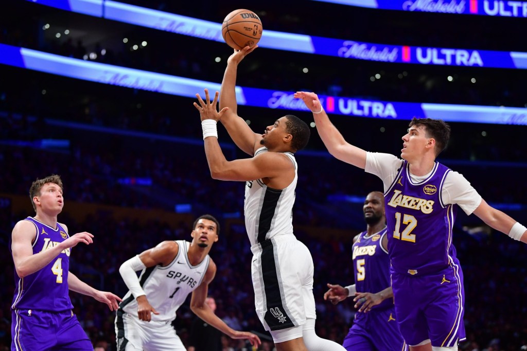 Nov 5, 2025; Los Angeles, California, USA; San Antonio Spurs forward Keldon Johnson (3) shoots ahead of Los Angeles Lakers forward Jake LaRavia (12) during the second half at Crypto.com Arena.