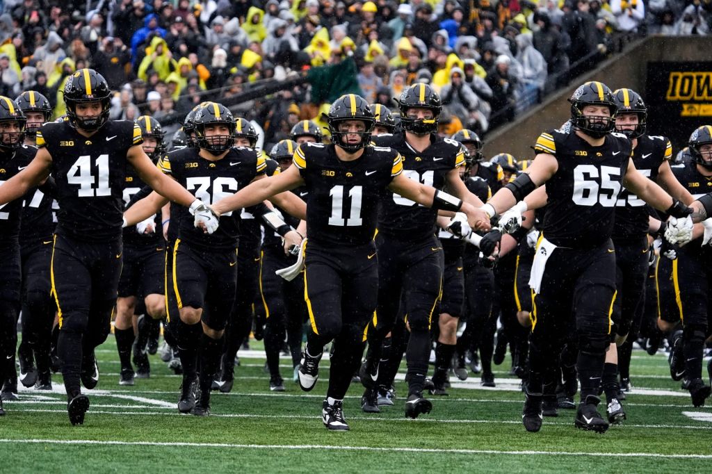 The Iowa Hawkeyes swarm onto the field Nov. 8, 2025 ahead of a Big Ten Football game against the Oregon Ducks at Kinnick Stadium in Iowa City, Iowa.