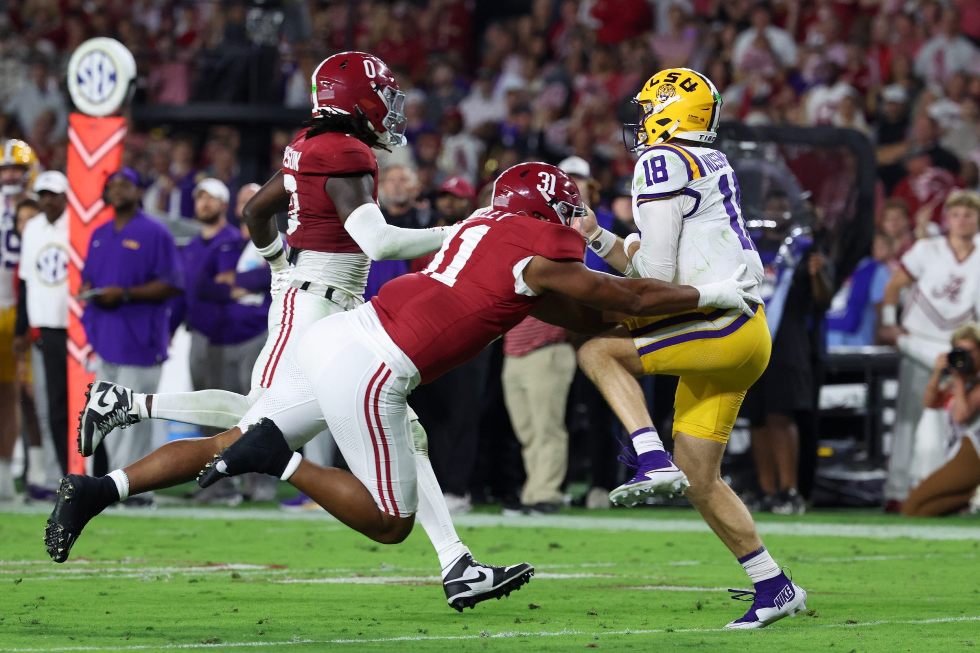 Nov 8, 2025; Tuscaloosa, Alabama, USA; Louisiana State Tigers quarterback Garrett Nussmeier (18) under pressure from Alabama Crimson Tide linebacker Deontae Lawson (0) and defensive lineman Keon Keeley (31) during the second quarter of the game at Saban Field at Bryant-Denny Stadium.
