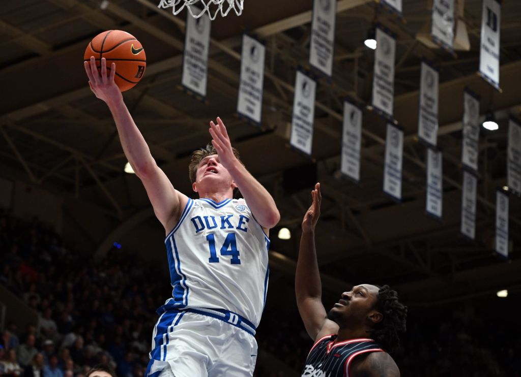 Nov 23, 2025; Durham, North Carolina, USA; Duke Blue Devils forward Nikolas Khamenia (14) lays the ball up in front of Howard Bison guard Bryce Harris (34) during the second half at Cameron Indoor Stadium.