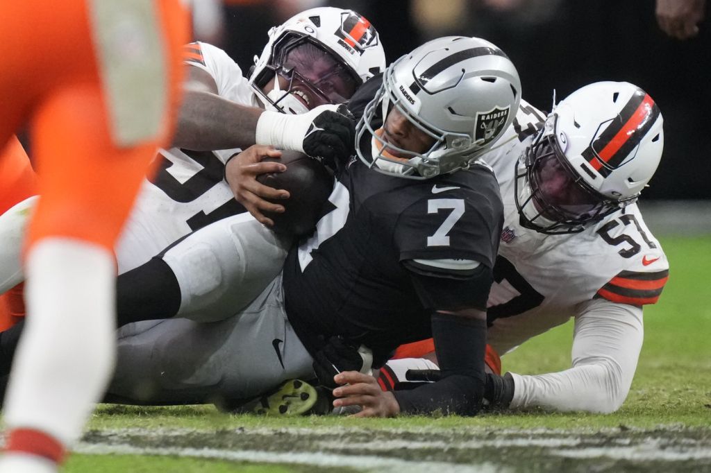 Nov 23, 2025; Paradise, Nevada, USA;Las Vegas Raiders quarterback Geno Smith (7) is sacked by Cleveland Browns defensive tackle Mike Hall Jr. (51) and defensive end Isaiah McGuire (57) in the second half at Allegiant Stadium.