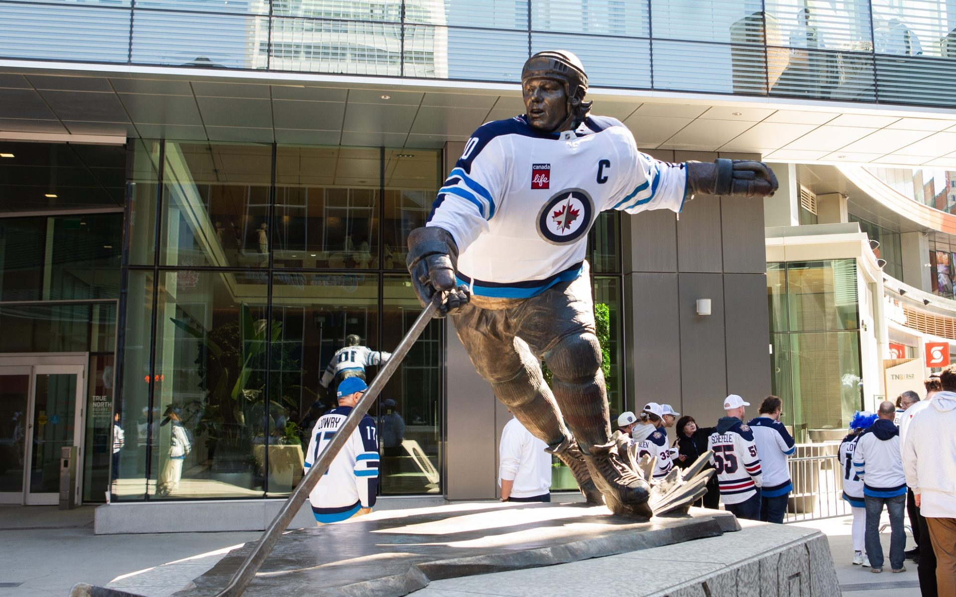 Apr 19, 2025; Winnipeg, Manitoba, CAN; Fans admire the statute of Dale Hawerchuk before the first period in game one of the first round of the 2025 Stanley Cup Playoffs at Canada Life Centre.