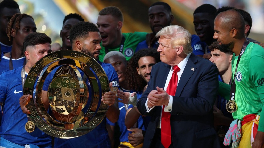 Jul 13, 2025; East Rutherford, New Jersey, USA; Chelsea FC defender Reece James (24) lifts the trophy as he celebrates with teammates as U.S. president Donald Trump after the final of the 2025 FIFA Club World Cup at MetLife Stadium.