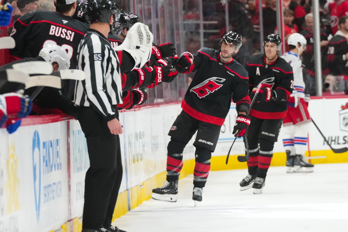 Nov 15, 2025; Raleigh, North Carolina, USA; Carolina Hurricanes defenseman Shayne Gostisbehere (4) celebrates with teammates after scoring a goal against the New York Rangers during the second period at Lenovo Center.