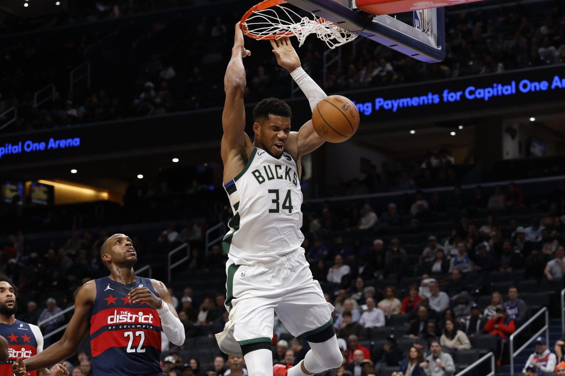 Dec 1, 2025; Washington, District of Columbia, USA; Milwaukee Bucks forward Giannis Antetokounmpo (34) dunks the ball as Washington Wizards forward Khris Middleton (22) looks on in the second quarter at Capital One Arena.