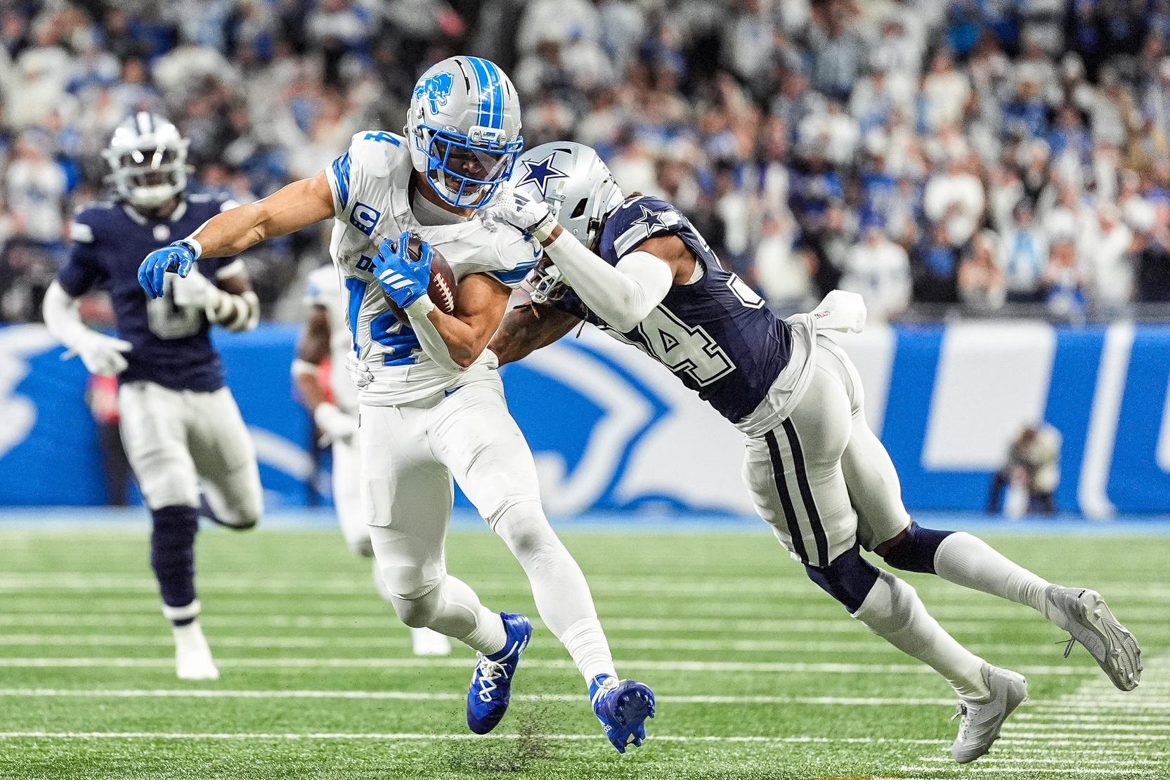 Detroit Lions wide receiver Amon-Ra St. Brown (14) makes a catch against Dallas Cowboys cornerback Shavon Revel Jr. (34) during the second half at Ford Field in Detroit on Thursday, Dec. 4, 2025.