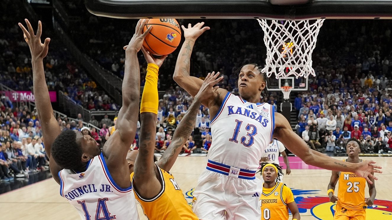 Dec 7, 2025; Kansas City, Missouri, USA; Missouri Tigers guard Sebastian Mack (12) shoots against Kansas Jayhawks guard Melvin Council Jr. (14) and guard Elmarko Jackson (13) during the second half at T-Mobile Center.