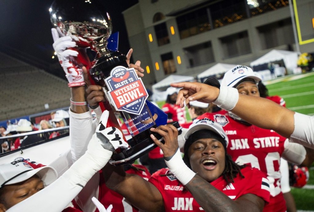 Jacksonville State Gamecocks running back Khristian Lando (22) hoists the trophy as Troy Trojans take on Jacksonville State Gamecocks during the IS4S Salute to Veterans Bowl at Cramton Bowl in Montgomery, Ala. on Wednesday, Dec. 17, 2025. Jacksonville State Gamecocks defeated Troy Trojans 17-13.