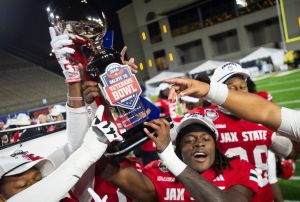 Jacksonville State Gamecocks running back Khristian Lando (22) hoists the trophy as Troy Trojans take on Jacksonville State Gamecocks during the IS4S Salute to Veterans Bowl at Cramton Bowl in Montgomery, Ala. on Wednesday, Dec. 17, 2025. Jacksonville State Gamecocks defeated Troy Trojans 17-13.