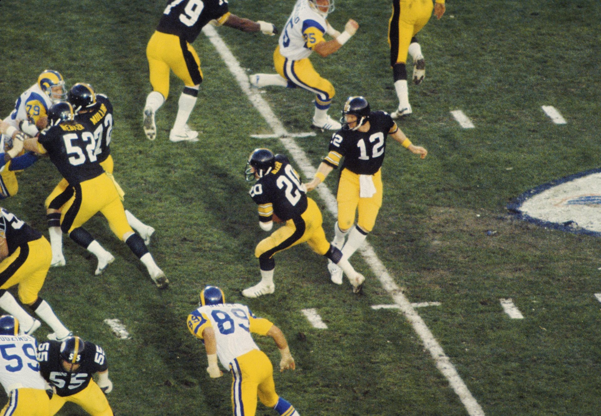 Jan 20, 1980; Pasadena, CA, USA; FILE PHOTO; Pittsburgh Steelers quarterback Terry Bradshaw (12) hands off to running back Rocky Bleier (20) against the Los Angeles Rams during Super Bowl XIV at the Rose Bowl. The Steelers defeated the Rams 31-19.