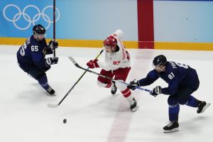 Feb 20, 2022; Beijing, China; Team ROC forward Vadim Shipachyov (87) skates with the puck as Team Finland forward Iiro Pakarinen (81) and Team Finland forward Sakari Manninen (65) defend in the third period during the Beijing 2022 Olympic Winter Games at National Indoor Stadium.