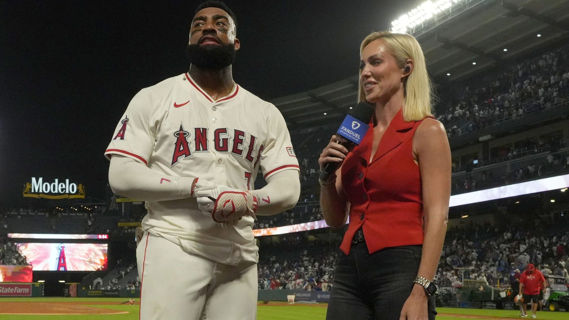 Aug 12, 2025; Anaheim, California, USA; FanDuel Sports Network reporter Erica Weston (right) interviews Los Angeles Angels right fielder Jo Adell (7) after the game against the Los Angeles Dodgers at Angel Stadium.