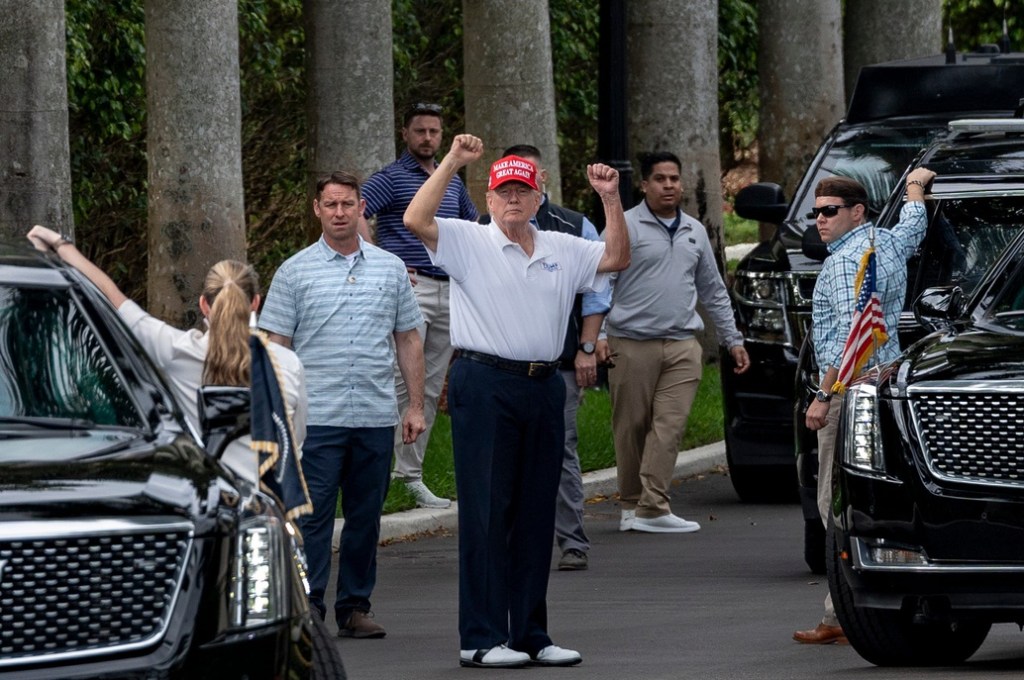 President Donald Trump raises his arms to supporters who gathered across the street fromTrump International Golf Club to celebrate President's Day in West Palm Beach, Florida on February 17, 2025.