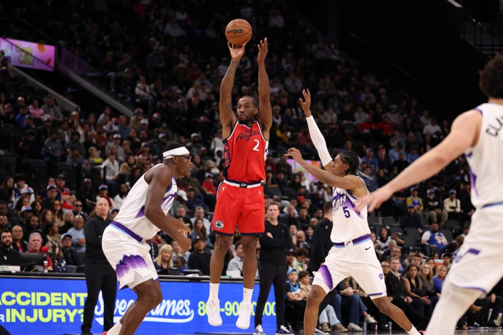 Jan 1, 2026; Inglewood, California, USA; Los Angeles Clippers forward Kawhi Leonard (2) shoots the ball between Utah Jazz forward Oscar Tshiebwe (left) and forward Cody Williams (5) during the second half at Intuit Dome.