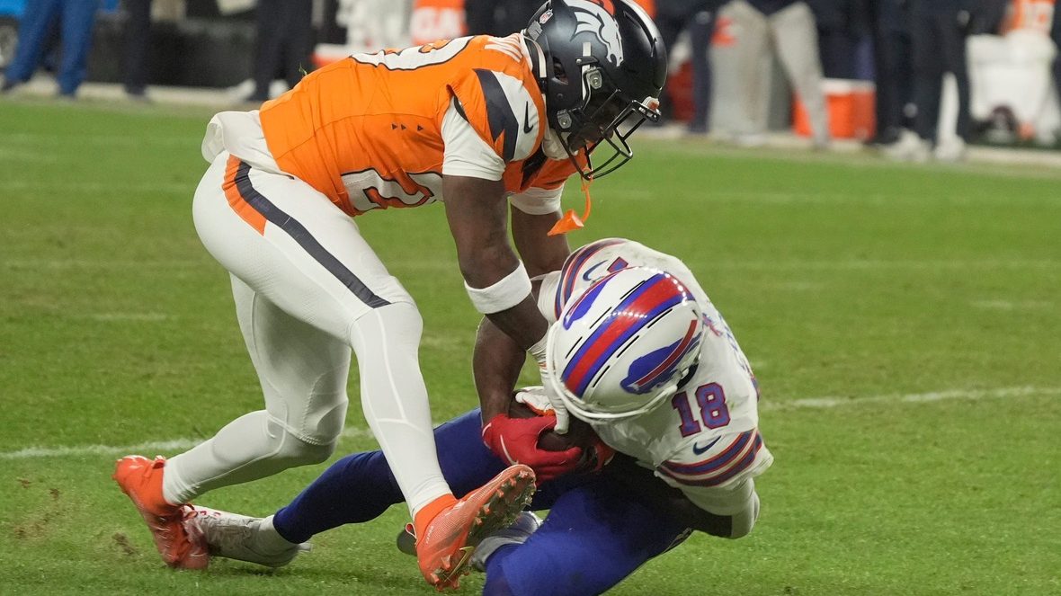 Denver Broncos cornerback Ja'quan McMillian reaches in on Buffalo Bills wide receiver Brandin Cooks who has the ball and whose knee is on the ground during overtime at Empower FIeld at Mile High in Denver, Colorado on Jan. 17, 2026.