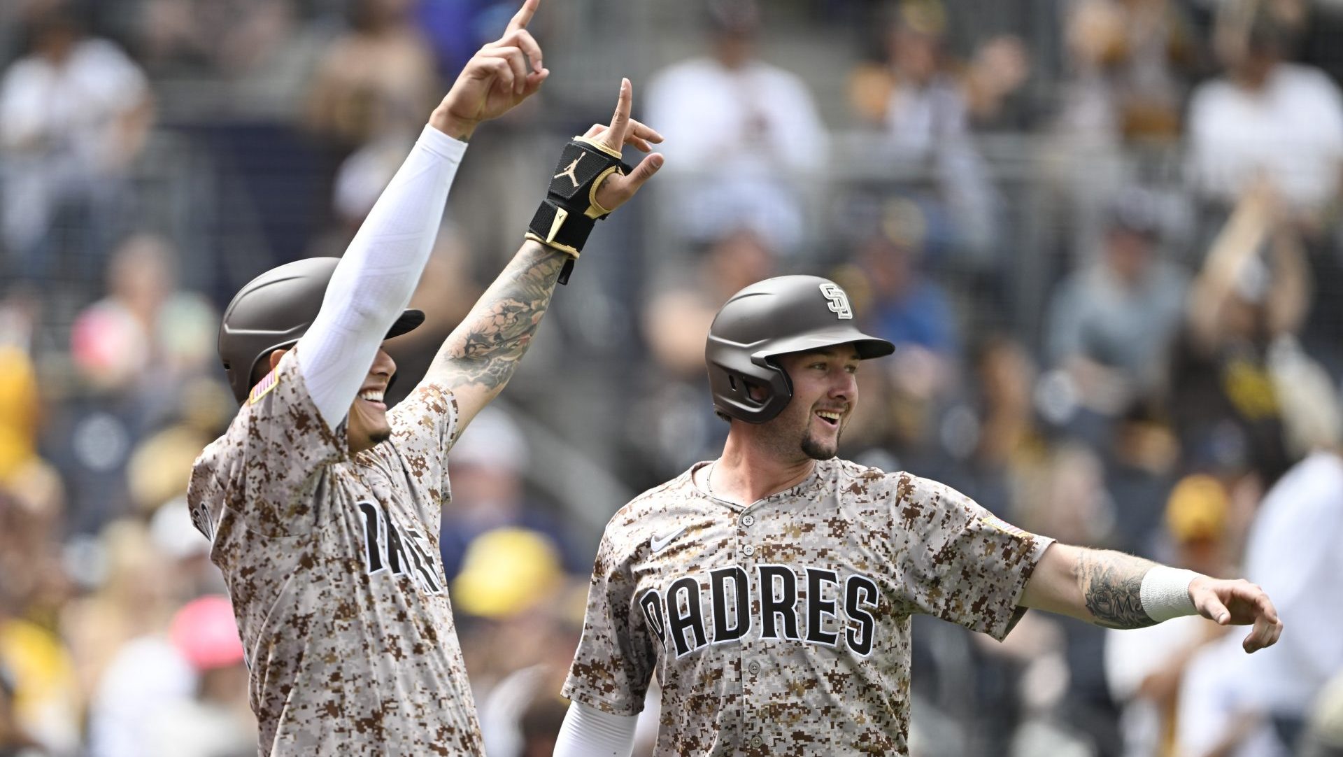 Sep 28, 2025; San Diego, California, USA; San Diego Padres third baseman Manny Machado (13), left, and Jackson Merrill (3) celebrate after scoring during the first inning against the Arizona Diamondbacks at Petco Park.