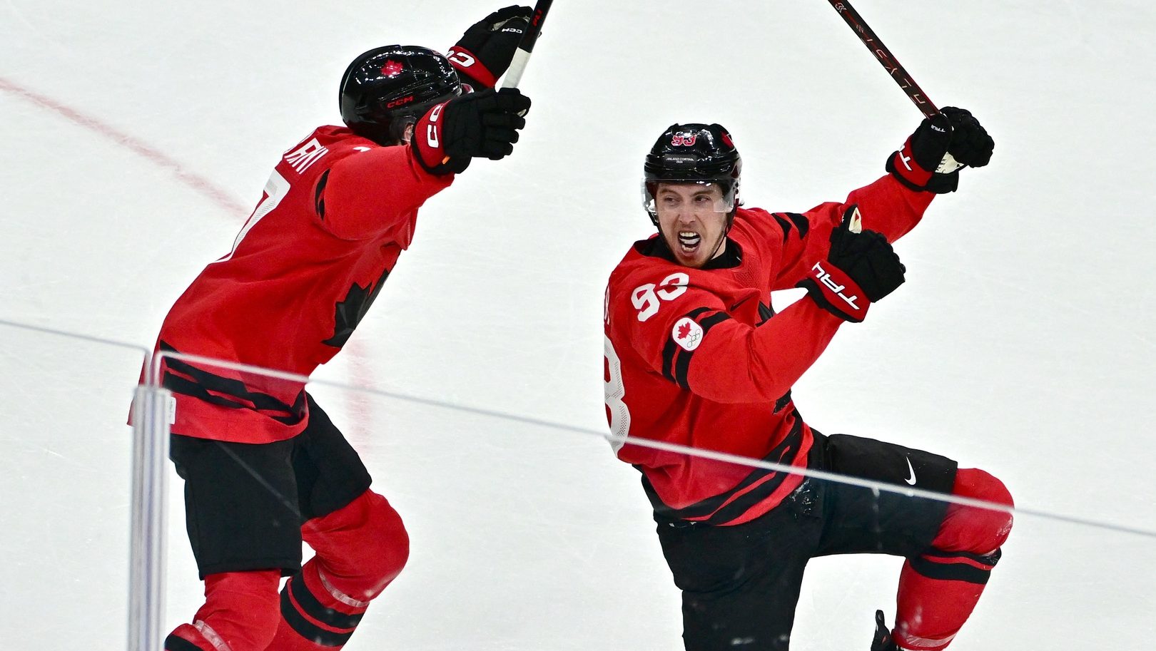 Feb 18, 2026; Milan, Italy; Mitch Marner of Canada celebrates with Macklin Celebrini after scoring their fourth goal in overtime to win the match against Czechia in a men's ice hockey quarterfinal during the Milano Cortina 2026 Olympic Winter Games at Milano Santagiulia Ice Hockey Arena.