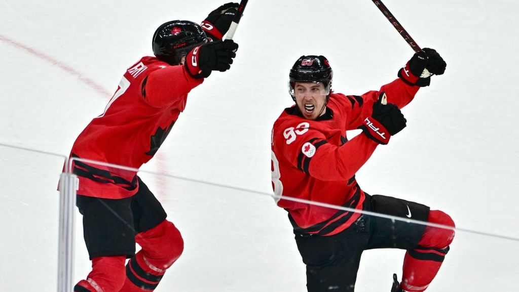 Feb 18, 2026; Milan, Italy; Mitch Marner of Canada celebrates with Macklin Celebrini after scoring their fourth goal in overtime to win the match against Czechia in a men's ice hockey quarterfinal during the Milano Cortina 2026 Olympic Winter Games at Milano Santagiulia Ice Hockey Arena.